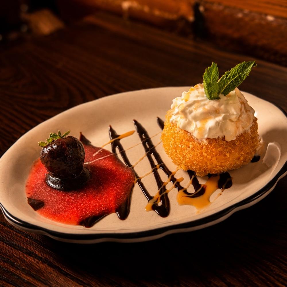 Fried vanilla ice cream with strawberry, orange-chocolate and whipped cream